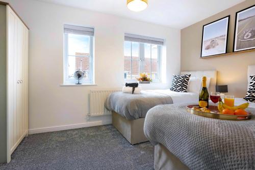 a bedroom with two beds and a table with fruit on it at Stylish House - Close to City Centre and Luton Airport - Free Parking, Super-Fast Wifi, Garden and Smart TV with Netflix by Yoko Property in Luton