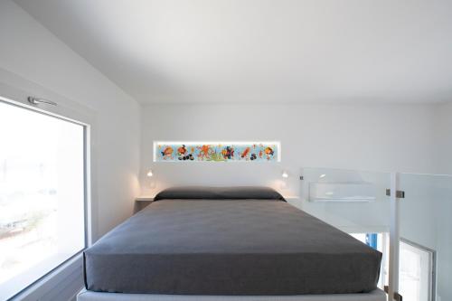 um quarto com uma cama num quarto com uma janela em EGIDA camere mediterranee em Favignana