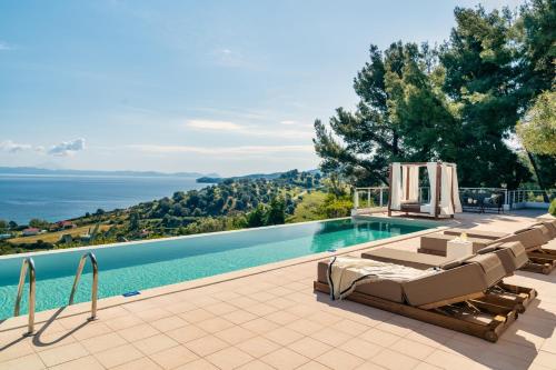 a villa with a swimming pool with a view of the ocean at Kappa Resort in Paliouri