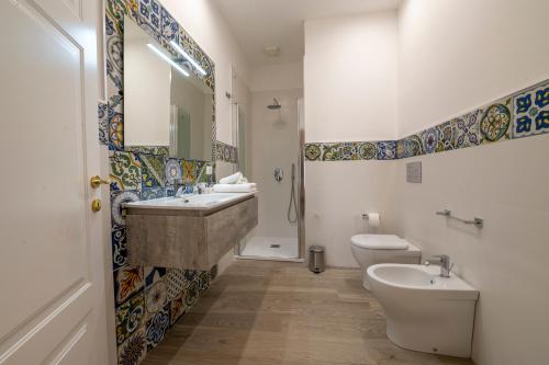 a bathroom with a sink and a toilet and a mirror at Domus Federiciana in Castellammare del Golfo