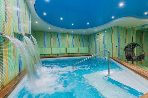 a indoor swimming pool with a water slide at Rixwell Segevold Hotel in Sigulda