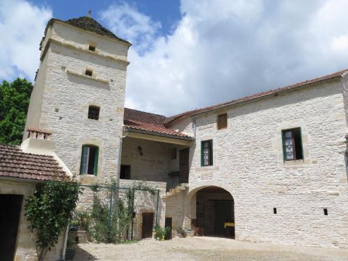 un gran edificio de piedra con una torre y una puerta en Holiday Home Le Mas de Serre by Interhome, en Nuzéjouls
