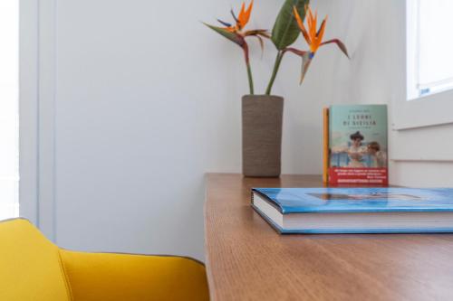 um livro sentado em cima de uma mesa com um vaso em EGIDA camere mediterranee em Favignana