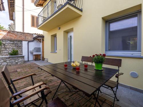 a wooden table with chairs and flowers on a patio at Holiday Home Le Mura by Interhome in Cividale del Friuli