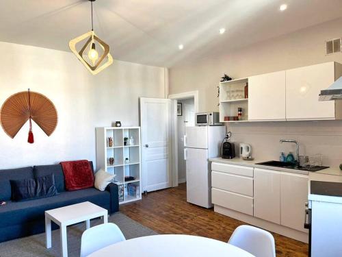 un salon avec un canapé bleu et une cuisine dans l'établissement Camille - Charmant T2 Moderne et Calme, à Châteaurenard