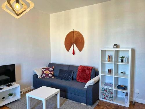 un salon avec un canapé bleu et une télévision dans l'établissement Camille - Charmant T2 Moderne et Calme, à Châteaurenard