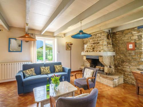 uma sala de estar com um sofá azul e uma lareira de pedra em Holiday Home Pen Ilis by Interhome em Saint-Jean-Trolimon