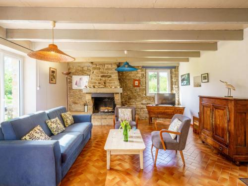 a living room with a blue couch and a table at Holiday Home Pen Ilis by Interhome in Saint-Jean-Trolimon