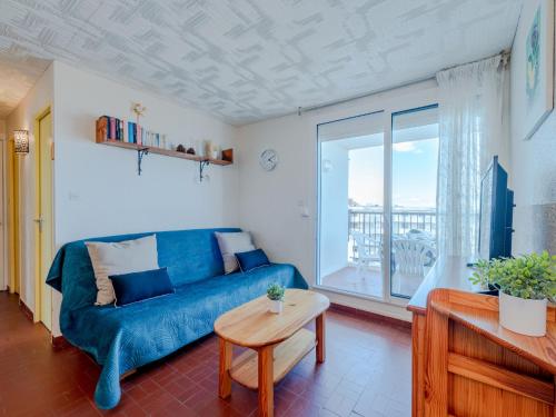 un salon avec un canapé bleu et une table dans l'établissement Apartment Le Grand Pavois by Interhome, au Barcarès