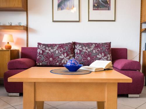 ein Wohnzimmer mit einem Sofa und einem Tisch mit einem Buch in der Unterkunft Apartment B313 by Interhome in Lahnstein