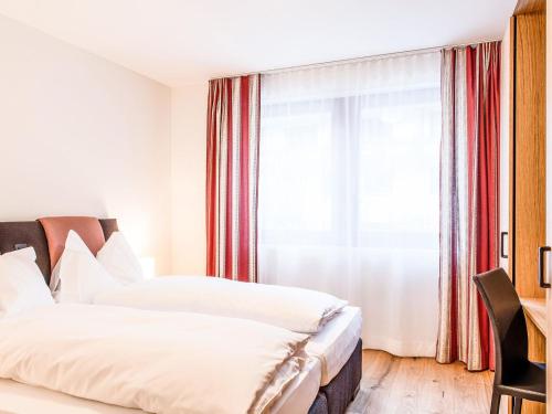エンゲルベルクにあるApartment TITLIS Resort 3-Zimmer Wohnung 8 by Interhomeのベッド2台と窓が備わるホテルルームです。