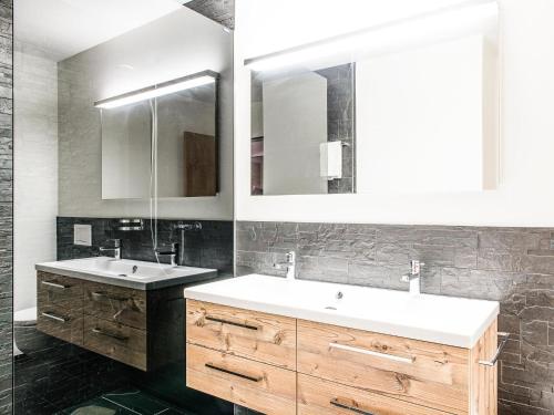 ein Badezimmer mit 2 Waschbecken und einem Spiegel in der Unterkunft Apartment TITLIS Resort 3-Zimmer Familienwohnung 2 in Engelberg