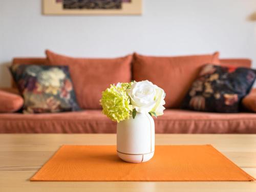 eine weiße Vase mit weißen Blumen auf dem Tisch in der Unterkunft Apartment A1208 by Interhome in Lahnstein