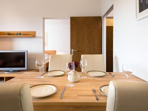 einen Holztisch mit Tellern und Weingläsern darauf in der Unterkunft Apartment A1208 by Interhome in Lahnstein