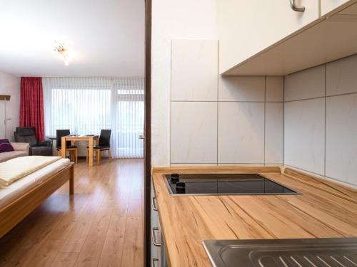 Apartment A110 by Interhome في لانشتاين: مطبخ مفتوح وغرفة معيشة مع أريكة
