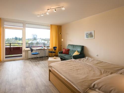 a bedroom with a bed and a couch and a table at Apartment B807 by Interhome in Lahnstein