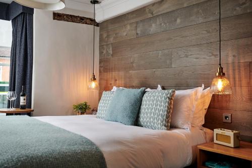 a bedroom with a bed with a wooden wall at The Red Lion in Odiham