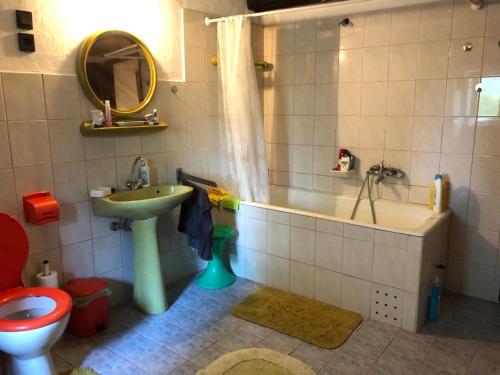 łazienka z umywalką, wanną i toaletą w obiekcie Tiszakanyar Vendégház w mieście Tiszadada