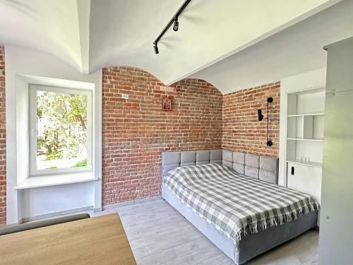 a bedroom with a bed against a brick wall at Котляревського апартамент з садом in Lviv