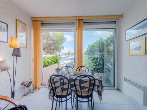 une salle à manger avec une table et des chaises et une fenêtre dans l'établissement Holiday Home Nautica-3 by Interhome, au Barcarès