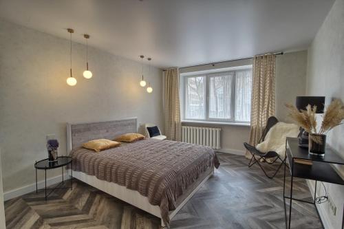 a bedroom with a bed and a desk and a window at Esu namie in Šiauliai