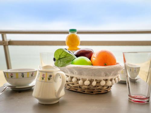 une corbeille de fruits assise sur une table avec des tasses dans l'établissement Apartment Milos by Interhome, à Canet