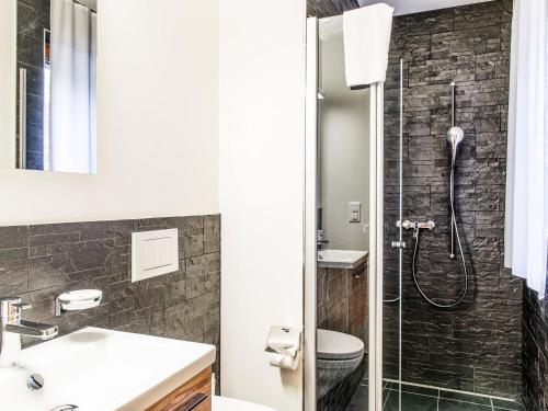 a bathroom with a shower and a sink and a toilet at Apartment TITLIS Resort 3-Zimmer Wohnung 10 in Engelberg