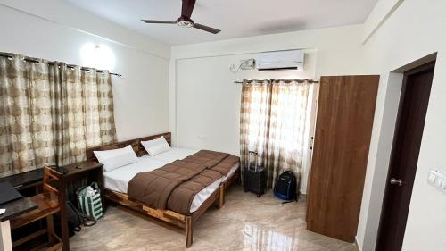 um quarto com uma cama e uma ventoinha de tecto em Goshen Inn em Bangalore