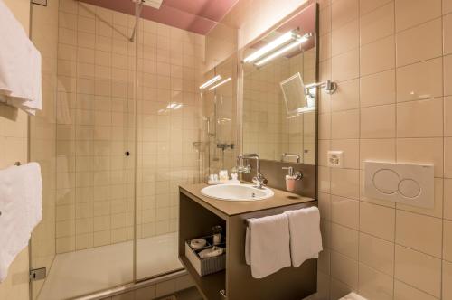 a bathroom with a sink and a shower at Boutique Hotel KARL in Luzern