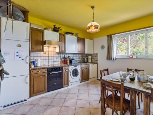 una cocina con electrodomésticos blancos y una mesa con sillas. en Apartment Casa Rosalia by Interhome, en Agarone