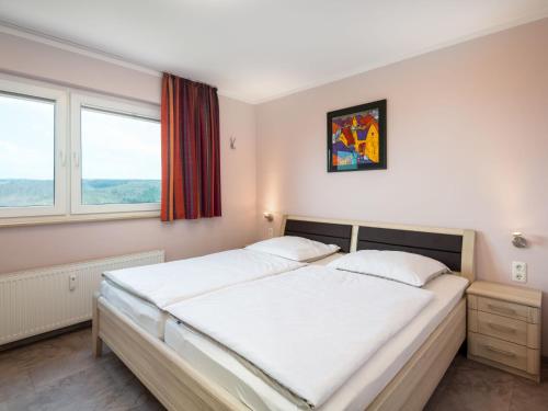 sypialnia z dużym łóżkiem i 2 oknami w obiekcie Apartment B1014 by Interhome w mieście Lahnstein