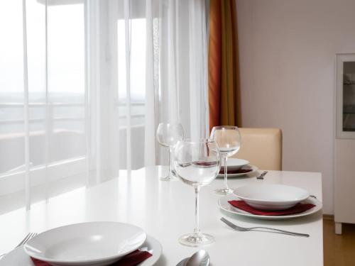- une table avec deux verres à vin et des assiettes dans l'établissement Apartment A1001 by Interhome, à Lahnstein