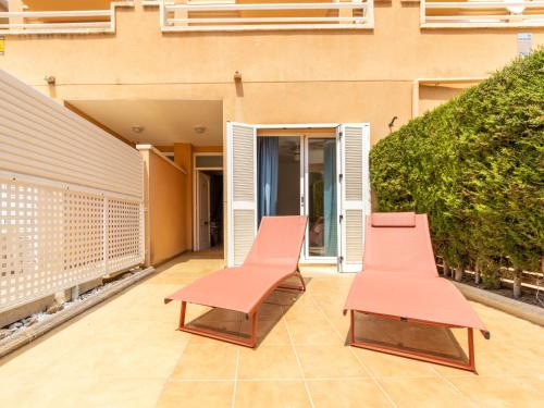 two benches sitting on a patio in front of a building at Holiday Home Canción de mar by Interhome in Creixell