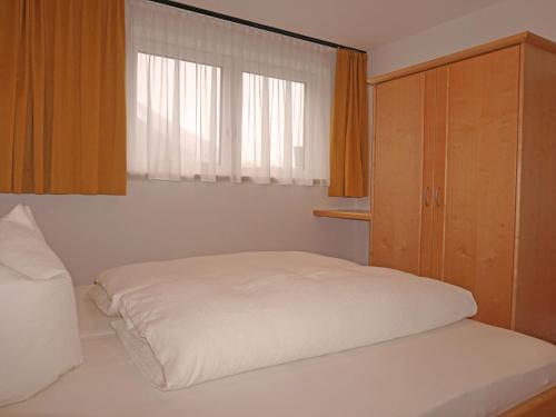 a small bedroom with a bed and a window at Apartment Freiheit-La by Interhome in Schnann
