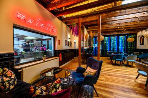 a lobby of a restaurant with chairs and tables at Nikii Boutique Hotel in Leverkusen