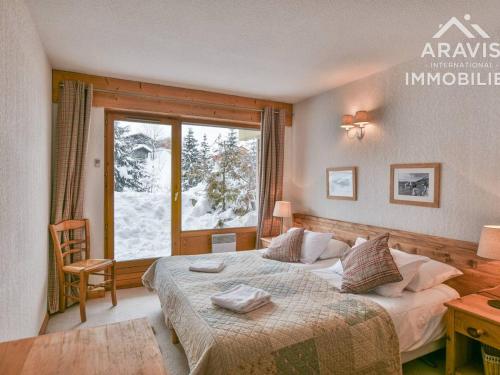 a bedroom with a bed and a large window at Appartement Le Grand-Bornand, 5 pièces, 8 personnes - FR-1-391-94 in Le Grand-Bornand