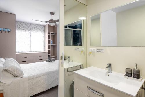 a bathroom with a bed and a sink and a mirror at Amplio Canet in Canet de Berenguer