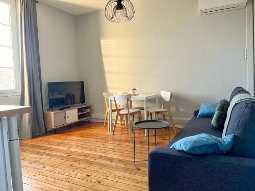 un salon avec un canapé et une table avec des chaises dans l'établissement Claire - Bel Appartement T2 Lumineux, à Châteaurenard