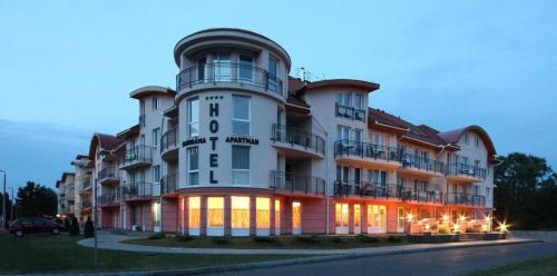 a large white building with a clock tower on it at Oázis Wellness Apartman2 in Hajdúszoboszló