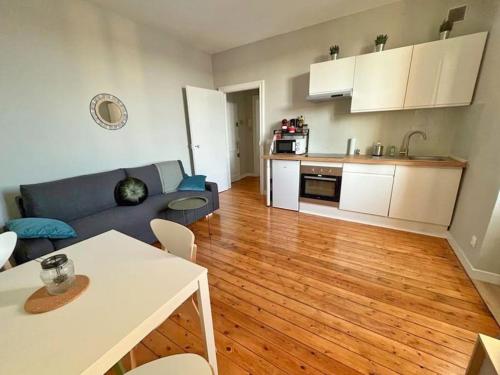 un salon avec un canapé et une cuisine dans l'établissement Claire - Bel Appartement T2 Lumineux, à Châteaurenard