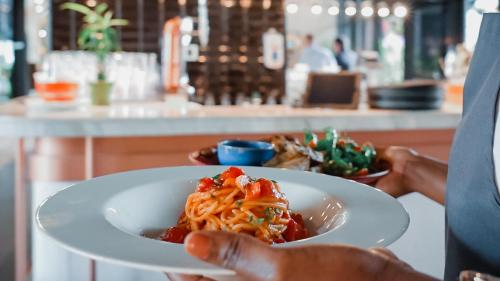 a person holding a white plate of food at Studio One Hotel in Dubai