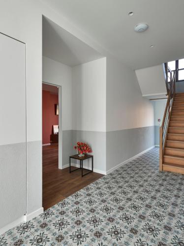 a hallway with a staircase and a table with flowers at Kamerrijk in Pepingen