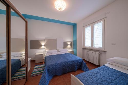 a bedroom with two beds and a mirror at Casa Vacanza Acqua Dolce in Maccagno Inferiore
