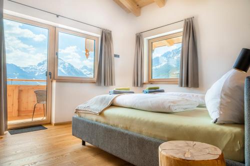 a bedroom with a bed and a large window at Appartement Bergpanorama Brandegg in Wagrain