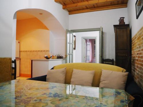 a living room with a table and a yellow couch at Carmona Center Apartment in Carmona