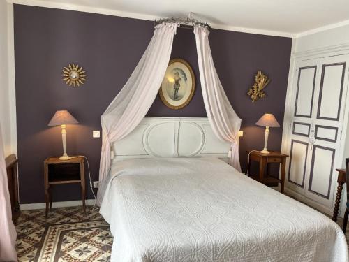 um quarto com uma cama de dossel branca em LA MAISON DE JUSTINE em Grimaud