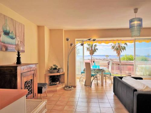 - un salon avec un canapé, une cheminée et une table dans l'établissement Appartement 2 pièces climatisé avec parking proche plage - FR-1-251-463, au Lavandou