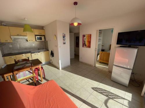 un salon avec une cuisine équipée d'un réfrigérateur dans l'établissement Bel T2 avec Garage, Terrasse et Animaux Admis - Saint-Cyprien Plage - FR-1-106-96, à Saint-Cyprien