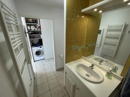 une salle de bain avec un lavabo et une machine à laver dans l'établissement Bel T2 avec Garage, Terrasse et Animaux Admis - Saint-Cyprien Plage - FR-1-106-96, à Saint-Cyprien
