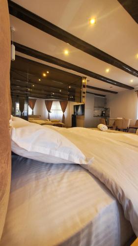 een slaapkamer met een groot bed met witte lakens bij Flux Studios Apart in Oradea